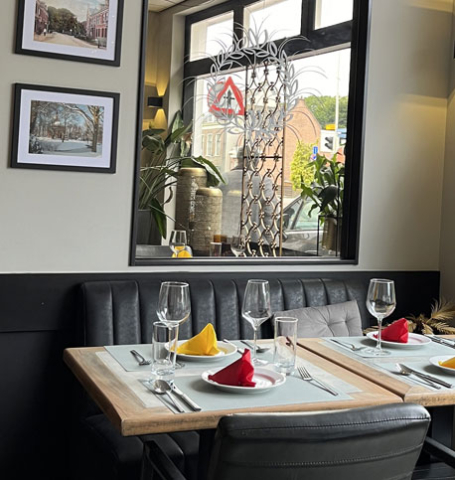 Interior of Anmool Restaurant with tables, chairs, and window view